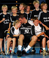 Stefan Lvgren und seine Kinder Linus und Thea sitzen in mitten eines Chores der Handball-Minis aus Melsdorf.