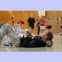 Trainingslager 2005: THW-Torwart Mattias Andersson liegt erschöpft auf dem Rücken mit dem Kopf auf einen Ball gelehnt. Im Hintergrund läuft der Trainingsbetrieb.